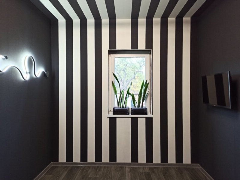 Дизайнерські шпалери з широкою чорною та білою смугою, в інтер'єрі стін та стелі, вертикальною та горизонтальною